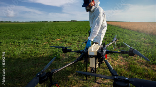 Modern technologies in agriculture. Industrial drone at green field for spraying pesticides to increase productivity and destroys harmful insects. Technologies in farming