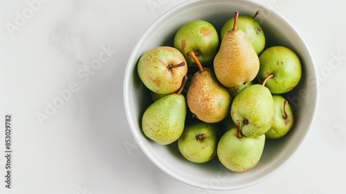 Green pears in a white bowl on a white background Abate fetel pears viewed from the top photo