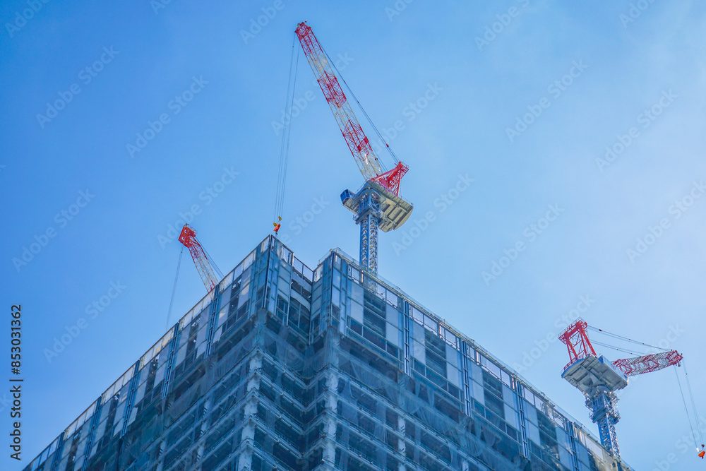 高層ビル建設のクレーンと青空