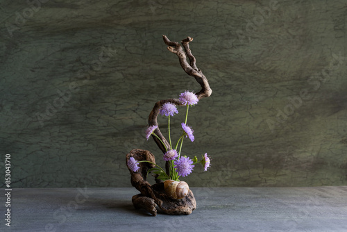 miniature composition of wildflowers using roots, moss, lichen, naturalistic style. photo