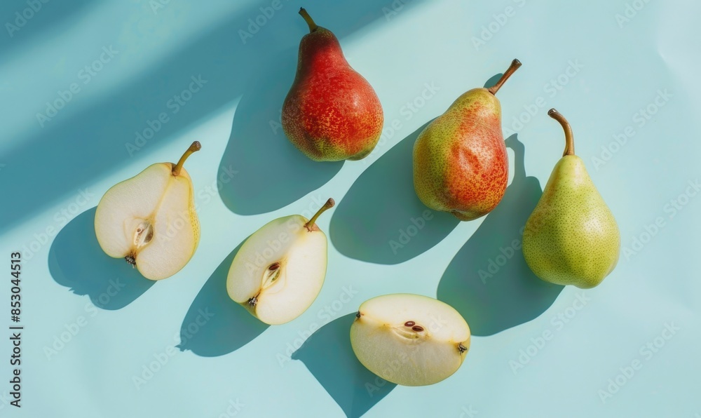 Green and red pears on a light blue surface Green and red pears on a light blue surface