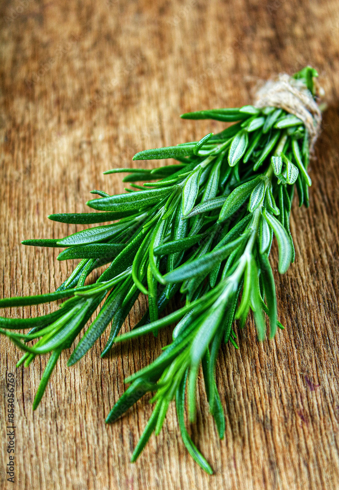 Rosemary on a wooden background. A bunch of fresh green fragrant rosemary. Spices and herbs, an ingredient for meat and fish. Culinary concept. Rosemary on a wooden background. A bunch of fresh green fragrant rosemary. Spices and herbs, an ingredient for meat and fish. Culinary concept.