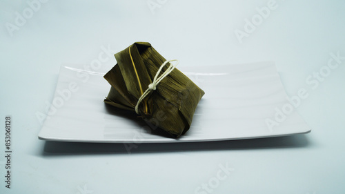 Traditional wrapped rice dumpling or zongzi on a plate photo