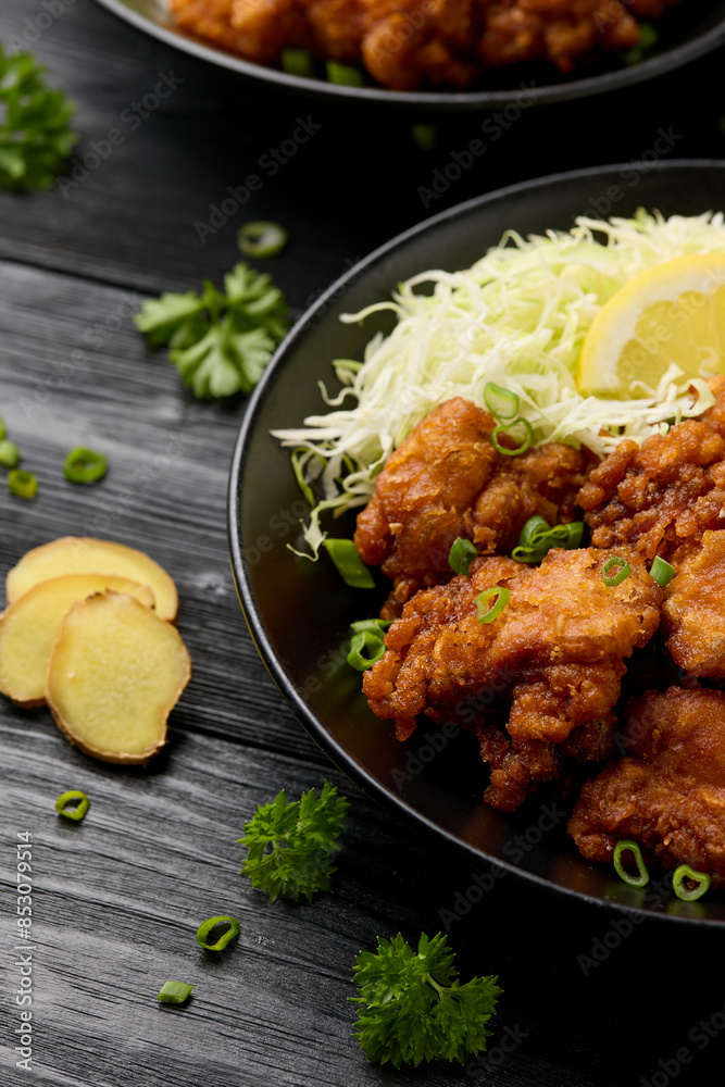 Japanese Fried crispy Chicken Karaage in black bowl with rice and cabbage Japanese Fried crispy Chicken Karaage in black bowl with rice and cabbage