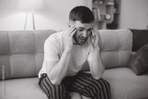 Obraz na plátně Depressed hopeless man in home wear lying on sofa during mental breakdown, psych
