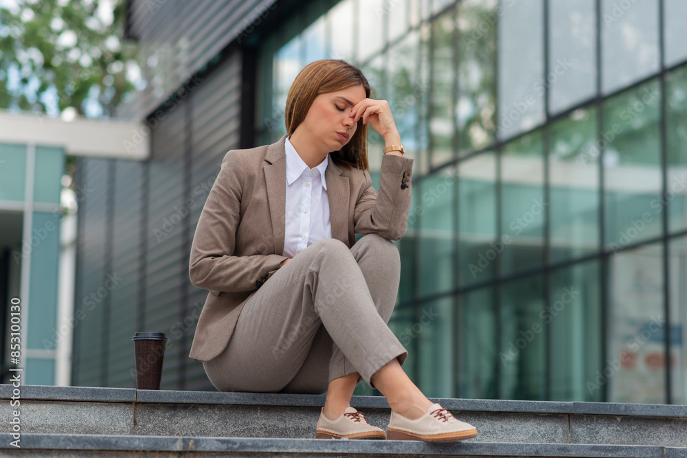 Fototapeta premium Business woman stressed from work while sitting outdoors on the stairs