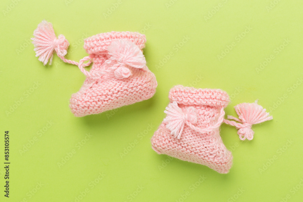 Pink baby booties on color background, top view Pink baby booties on color background, top view