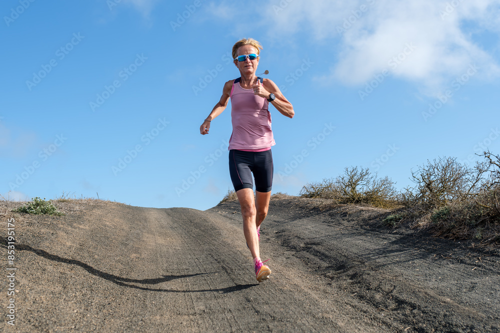 Athletic woman running on a remote volcanic barren road Athletic woman running on a remote volcanic barren road