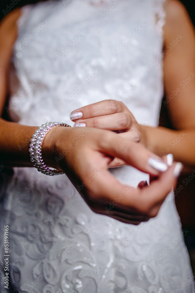 A detailed close-up of a bride adjusting a delicate wrist corsage, capturing the intricate details and the tender moments of the wedding preparation. A detailed close-up of a bride adjusting a delicate wrist corsage, capturing the intricate details and the tender moments of the wedding preparation.