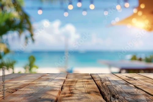 Wooden table with blurred background of beach bar and sea view at summer time for product display montage, vacation concept, banner design.