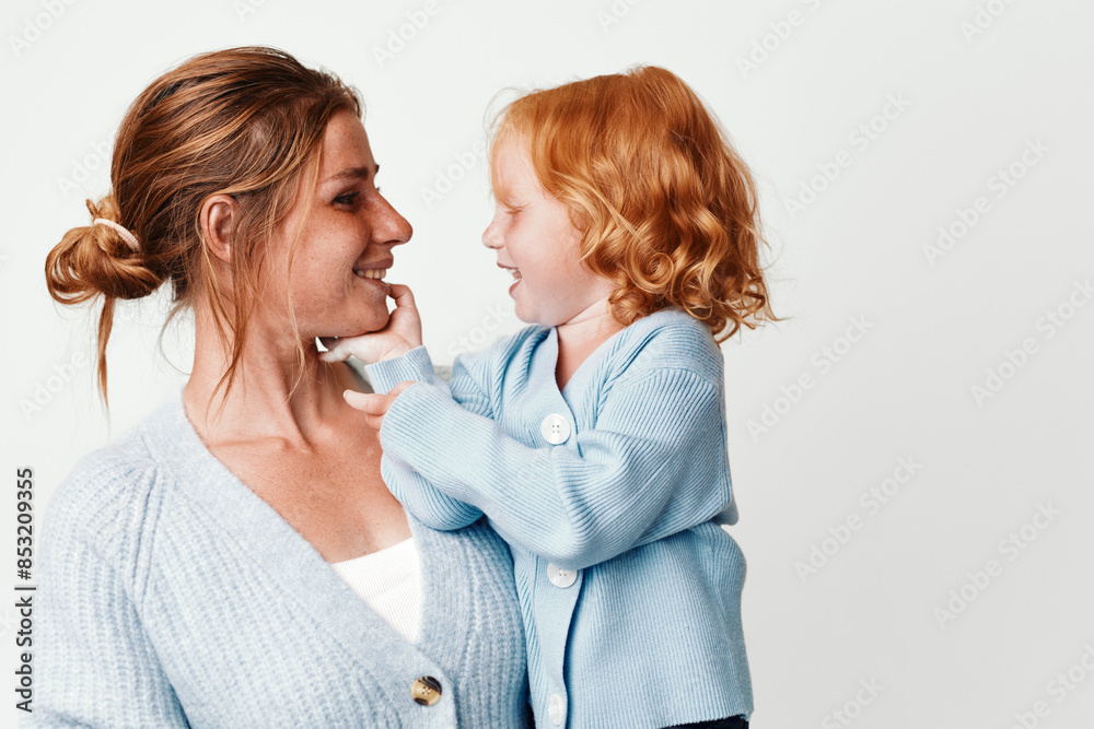 Family fun mother holding daughter in arms smiling at camera at beautiful destination