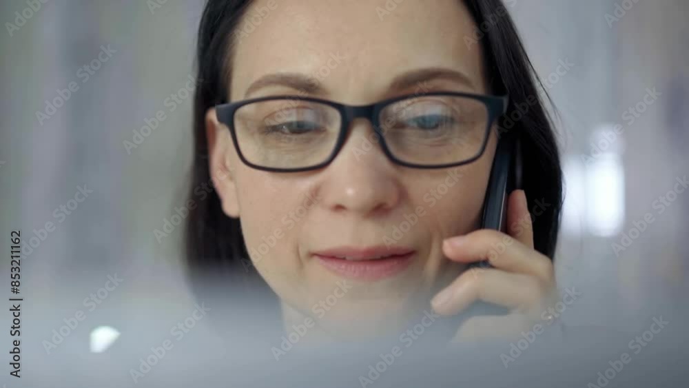 Cheerful smiling woman with glasses using a mobile phone, blurred background. Lifestyle and business concepts Cheerful smiling woman with glasses using a mobile phone, blurred background. Lifestyle and business concepts