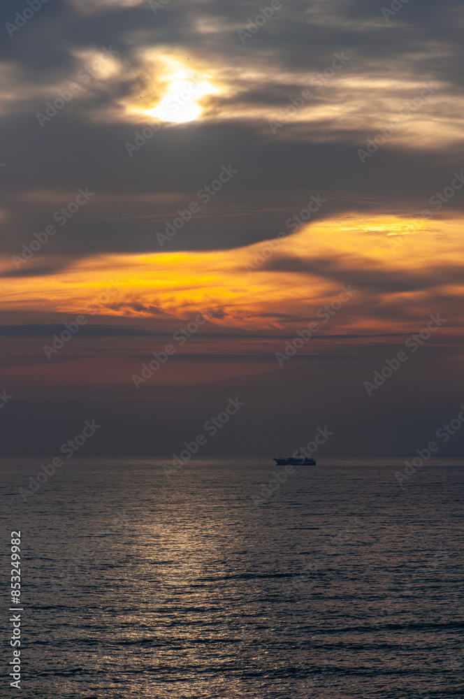 beautiful seascape on a cloudy autumn morning with a squid fishing boat anchored off the coast. Vertical image. beautiful seascape on a cloudy autumn morning with a squid fishing boat anchored off the coast. Vertical image.