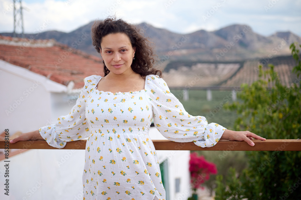 Naklejka premium Woman in floral dress posing outdoors in scenic countryside