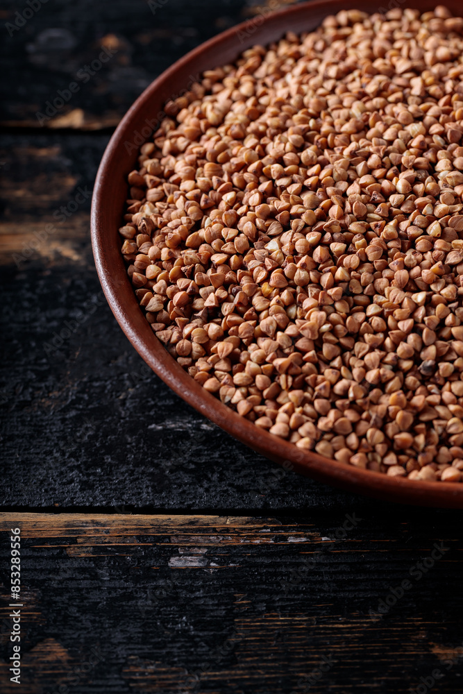 Raw Buckwheat Grains on Clay Plate, Copy Space Raw Buckwheat Grains on Clay Plate, Copy Space