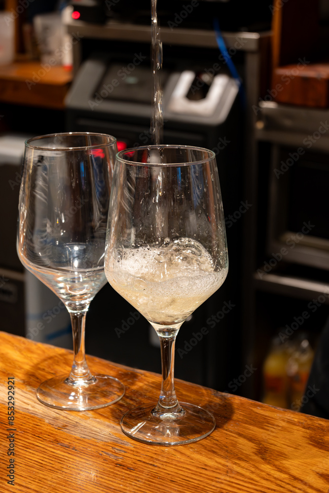 Pouring of txakoli or chacolí slightly sparkling very dry white wine produced in Spanish Basque Country in typical pinchos bar in old part of San Sebastian or Donostia, Spain Pouring of txakoli or chacolí slightly sparkling very dry white wine produced in Spanish Basque Country in typical pinchos bar in old part of San Sebastian or Donostia, Spain