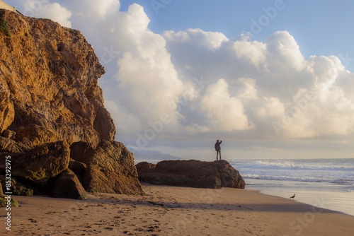 Man standing on a rock looking out over Ocean beach. San Francisco, Califormia, United States of America. photo