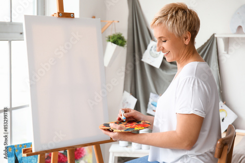 Mature female artist painti...