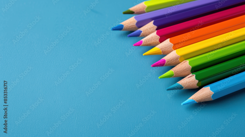 A row of colorful pencils on a blue background A row of colorful pencils on a blue background