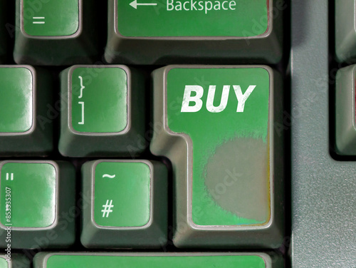 Worn heavily used green enter key with the word BUY on it on an old trader computer keyboard. Stock market trading, buying, day trading cryptocurrency, bull market AI trading bot abstract concept