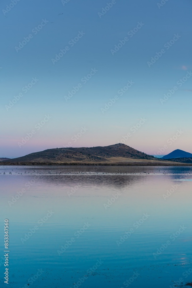 Calm tranquil lake at sunset with migratory birds. Indian Tom Lake, California, United States of America. Calm tranquil lake at sunset with migratory birds. Indian Tom Lake, California, United States of America.