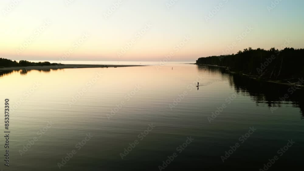 Immerse yourself in the serene beauty of a calm water scene at sunset, viewed from above in aerial footage Immerse yourself in the serene beauty of a calm water scene at sunset, viewed from above in aerial footage