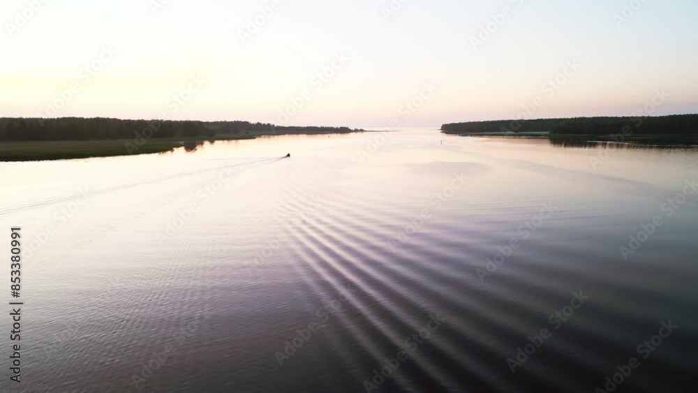 Serene sunrise view of a river with a distant boat gliding peacefully, creating a tranquil and picturesque scene Serene sunrise view of a river with a distant boat gliding peacefully, creating a tranquil and picturesque scene
