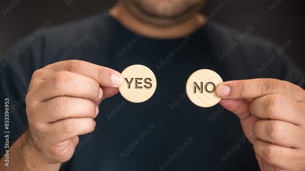 Man hand show yes or no on wood circle block. Yes No choice and decision. Options in difficult situations. True False, decision making. Man hand show yes or no on wood circle block. Yes No choice and decision. Options in difficult situations. True False, decision making.