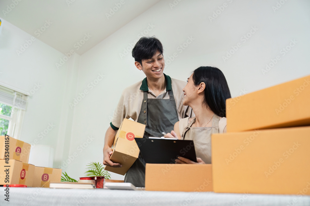Small Business Owner Working Together in Home Office, Packing Boxes for Online Orders, Smiling and Collaborating, E-commerce Startup, entrepreneur Couple, Home-Based Business Success Small Business Owner Working Together in Home Office, Packing Boxes for Online Orders, Smiling and Collaborating, E-commerce Startup, entrepreneur Couple, Home-Based Business Success