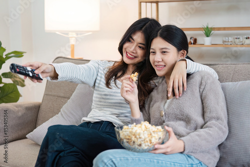 Happy LGBT Couple Relaxing at Home, Watching TV and Enjoying Popcorn Together in a Cozy Living Room Setting, Embracing Love and Togetherness, Celebrating Modern Lifestyle and Inclusivity