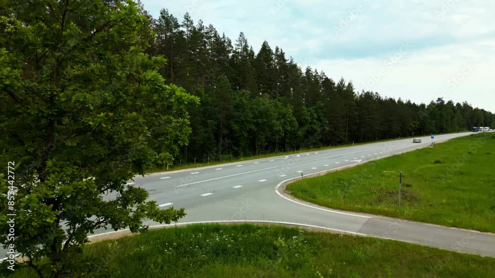 Enjoy a breathtaking aerial view of a car on a forest road, showing the lush greenery and surroundings in realtime Enjoy a breathtaking aerial view of a car on a forest road, showing the lush greenery and surroundings in realtime