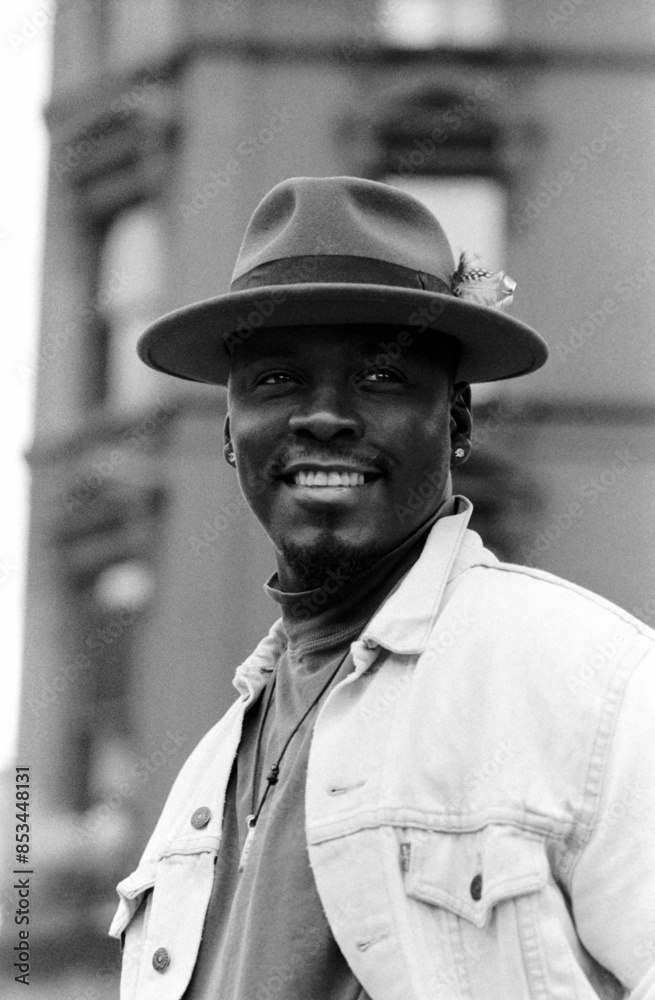Smiling man with a hat in a black and white urban portrait. Smiling man with a hat in a black and white urban portrait.