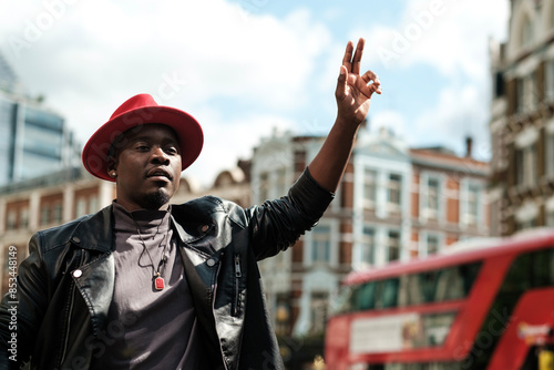 Low point of view of man hailing for a taxi in a busy London street. photo