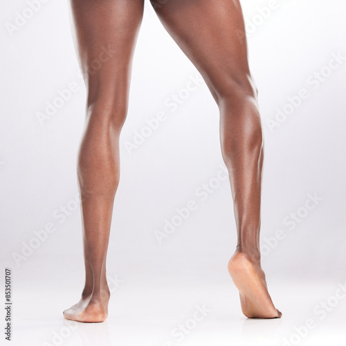 Person, legs and muscular in studio with fitness for workout progress, exercise goals and wellness. Bodybuilder, strong athlete and flexing thighs for healthy body and gym muscles on white background