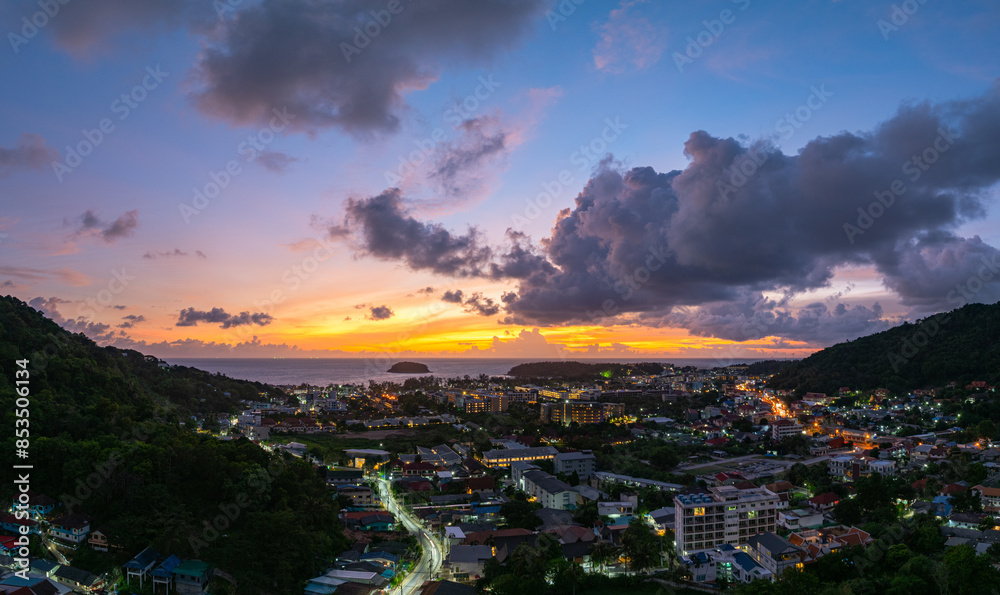 Obraz premium Aerial view Clouds obscure the beautiful sky as the sun sets. The lights along the beach begin to turn on as dusk approaches.There are many buildings, resorts, and hotels that accommodate tourists.