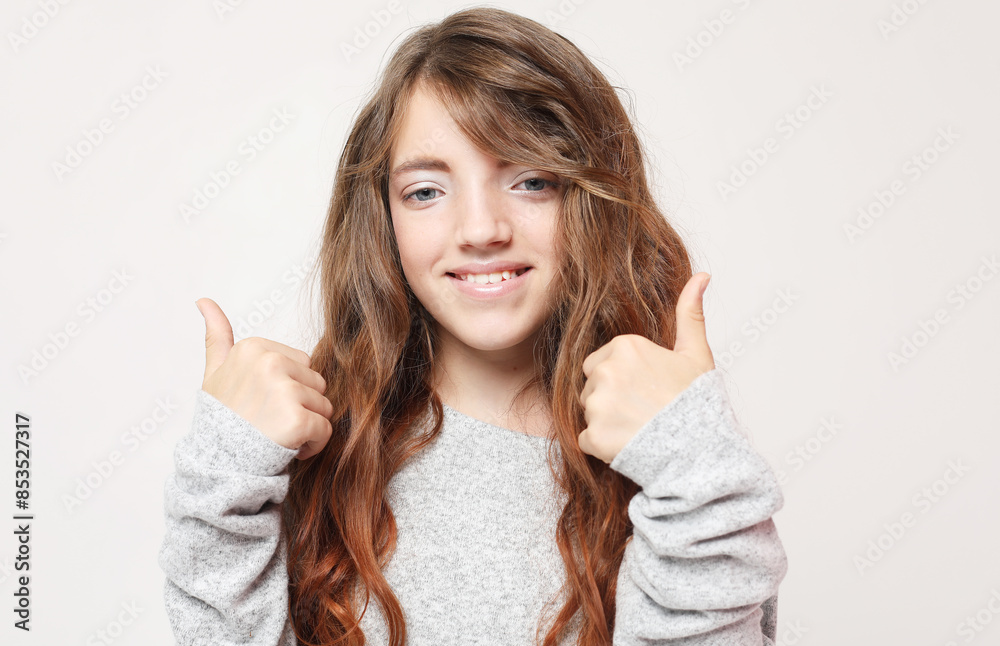 beautiful and confident child girl showing thumbs up over light grey background beautiful and confident child girl showing thumbs up over light grey background