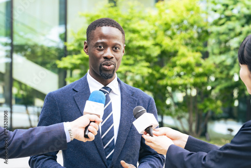 Black man being interviewed in front of a building photo