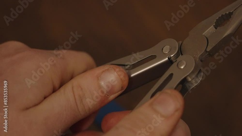 Unfoldoing a knife from a multi tool for electric repair. photo