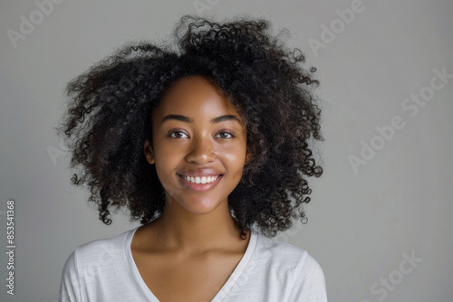 Confident young African American woman with a radiant smile against a studio backdrop