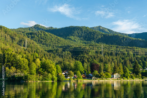 lake in the mountains with lush green trees © Dirk