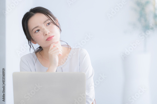 Plakat パソコン作業をする若い女性 考える悩むの頬杖のポーズ