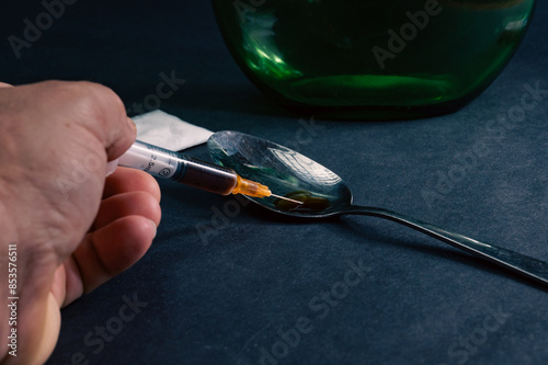 Obraz na płótnie Drug addiction concept. The syringe is filled with heroin prepared in a spoon. Dark background w salonie