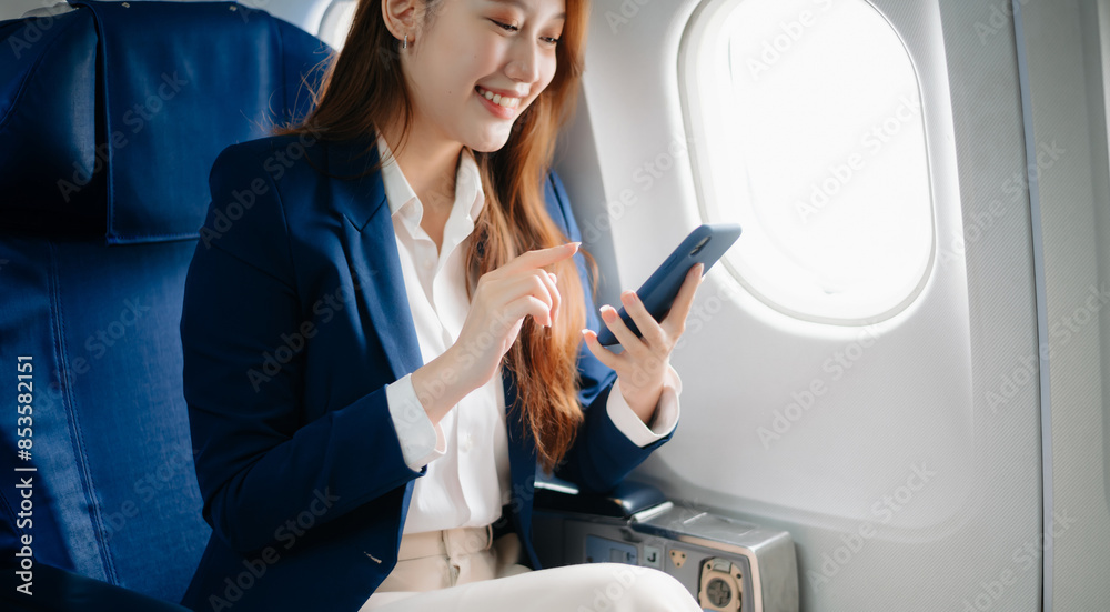 Young Asian executive excels in first class, multitasking with digital tablet, laptop and smartphone. Travel in style, work Young Asian executive excels in first class, multitasking with digital tablet, laptop and smartphone. Travel in style, work