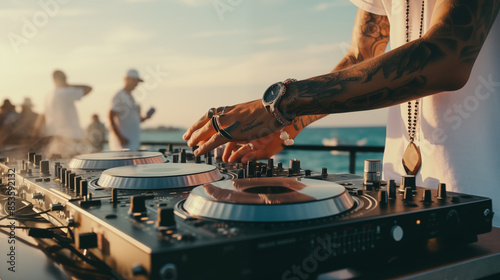 DJ mixing music on console mixer board at a luxury yacht party or at a beach party at sea, close-up of dj hands 