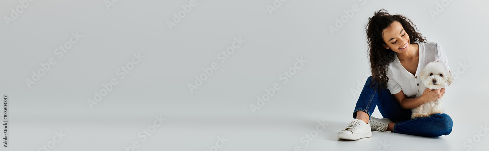 Young woman sits on floor, tenderly holding fluffy white dog. Young woman sits on floor, tenderly holding fluffy white dog.