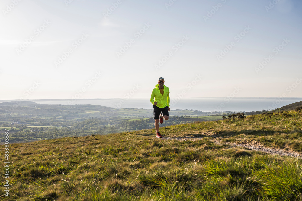 Active man running at mountain on sunny day Active man running at mountain on sunny day