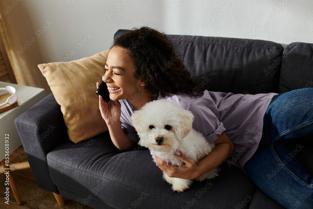 A woman sitting on a couch, gently cradling a white dog in her arms. A woman sitting on a couch, gently cradling a white dog in her arms.