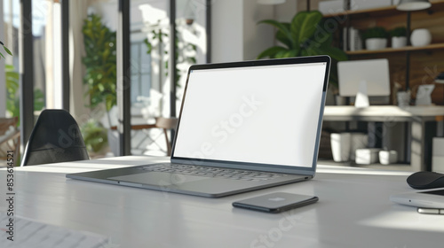 Laptop on a white table, screen blank. A mouse and smartphone are next to the laptop. The background is a home or office.