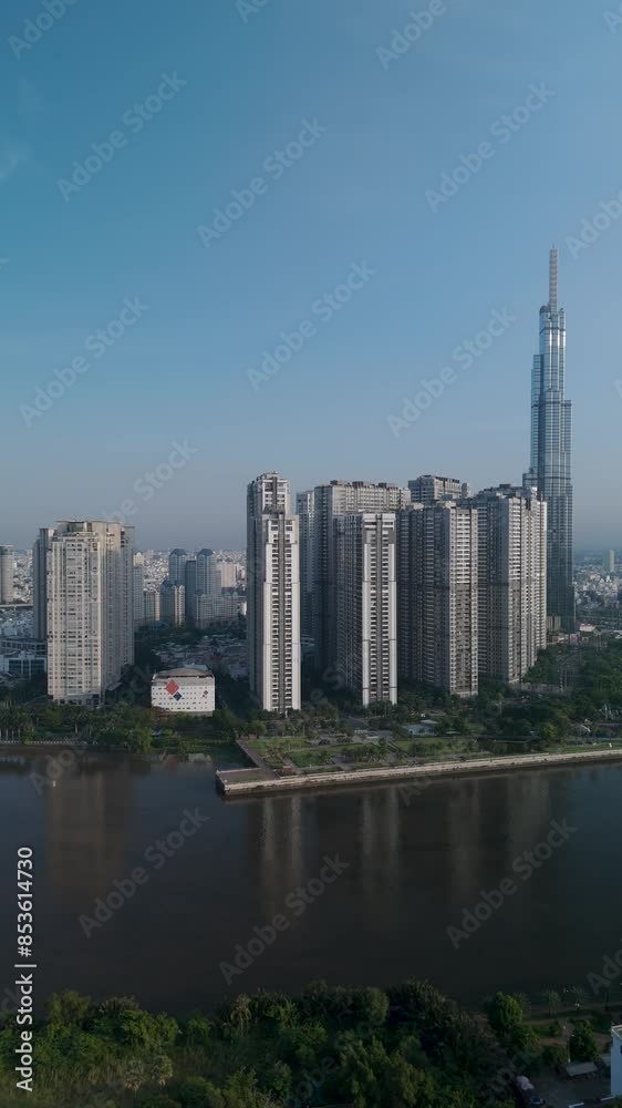 Landmark building on the Saigon River with clear blue sky vertical drone tracking shot. This is a feature of Ho Chi Minh City Skyline in Vietnam Landmark building on the Saigon River with clear blue sky vertical drone tracking shot. This is a feature of Ho Chi Minh City Skyline in Vietnam