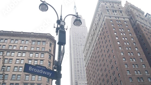 New York City crossroad, street intersection road sign on post. Empire State building, Midtown district, Broadway, 34, NYC, United States. Highrise skyscraper architecture, Bway corner text roadsign. photo